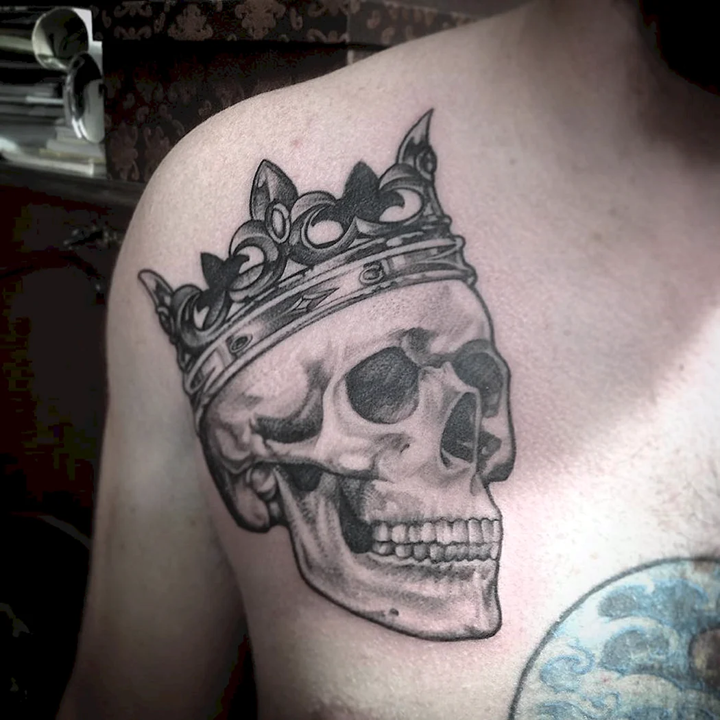 Череп у короні татуювання на грудях