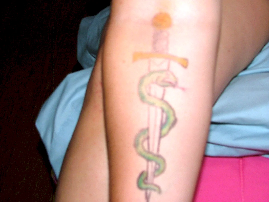 Тату змея обвивает меч