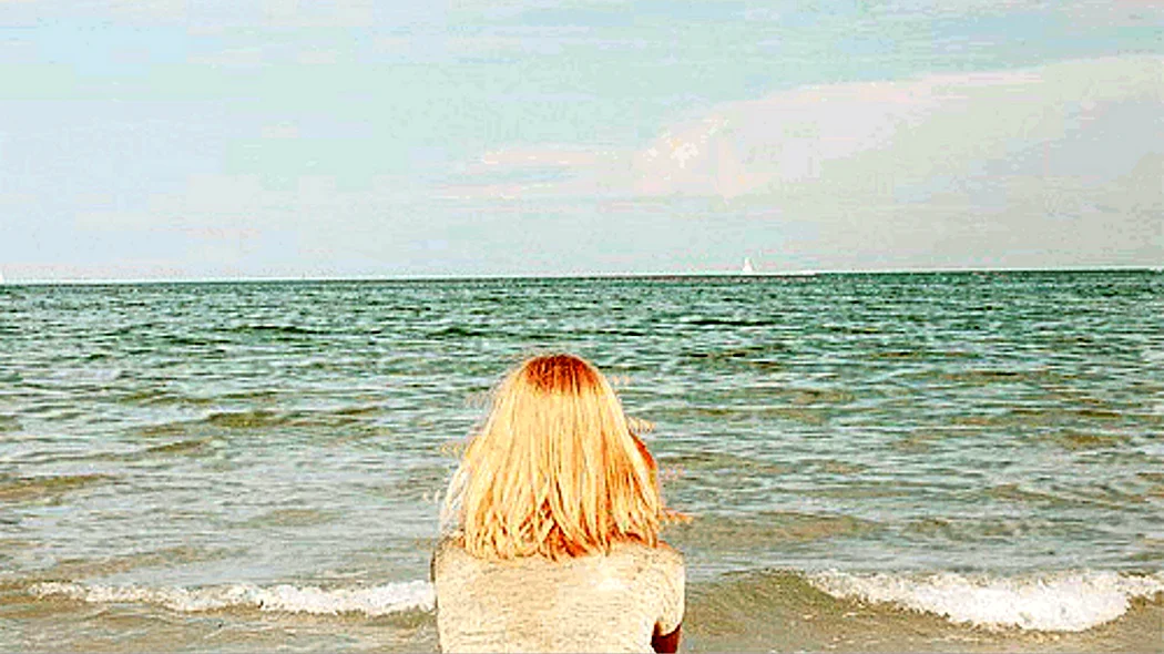 Блондинка на море со спины